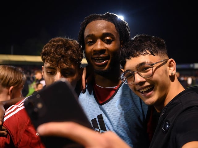 CRAWLEY, ENGLAND - AUGUST 23: James Balagizi of Crawley Town celebrates with fans following their side's victory in the Carabao Cup Second Round match between Crawley Town and Fulham at Broadfield Stadium on August 23, 2022 in Crawley, England. (Photo by Mike Hewitt/Getty Images)