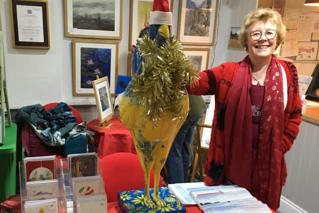 Volunteer Gay McCart with a festive Ukraini-Hen selling the HUb's own Christmas cards