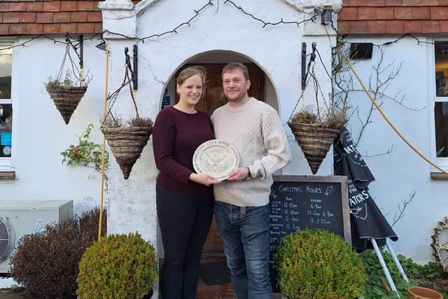 Sophie and Lee Forbes with the Amberley Pottery plate presented by grateful customers of the Sportman Inn at Amberley which has now closed