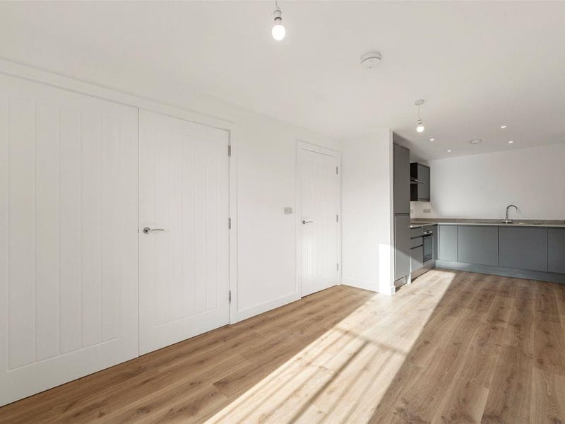 This apartment on the first floor is priced at £265,000. The open-plan layout effortlessly connects the dining area and kitchen, the bathroom has a bath and overhead shower, and there is a separate utility room.
