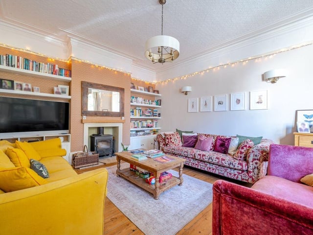 The bay-fronted sitting room has a fireplace and wood burner