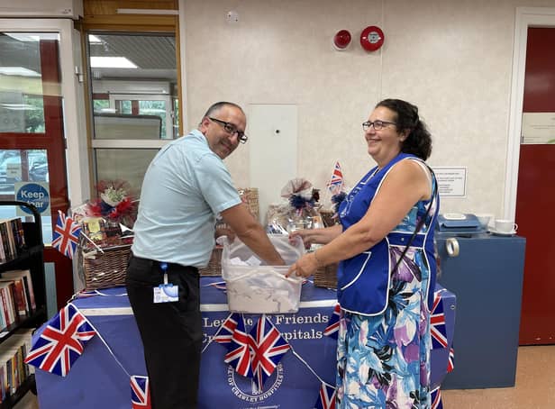 Rosalind Phipps, Chair of The League of Friends, with Miguel Da Silva, Receptionist at Crawley Hospital, drawing the lucky numbers