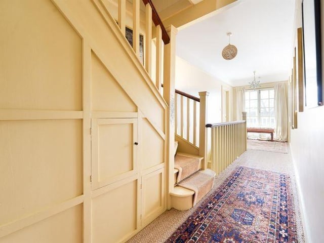 There is a panelled hallway with stairs to the first and second floors