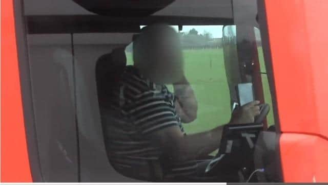 An HGV driver pictured with a mobile phone in each hand while travelling on the M4