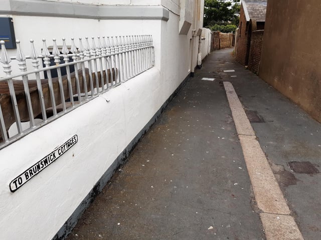 The small sign to Brunswick Cottages in the twitten at the back of the Coastguard House, which marks the historic boundary between Worthing and Heene