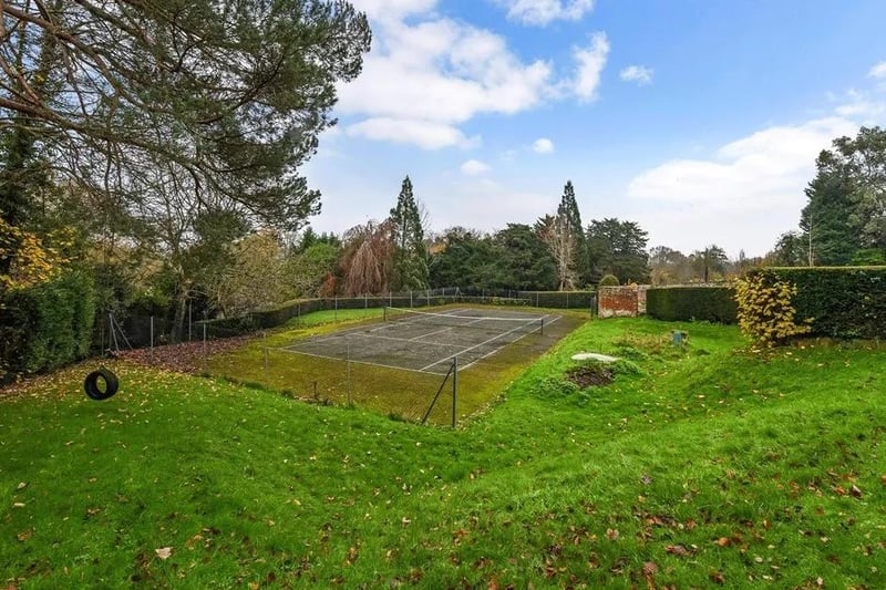 There is an orchard, walled swimming pool and tennis court