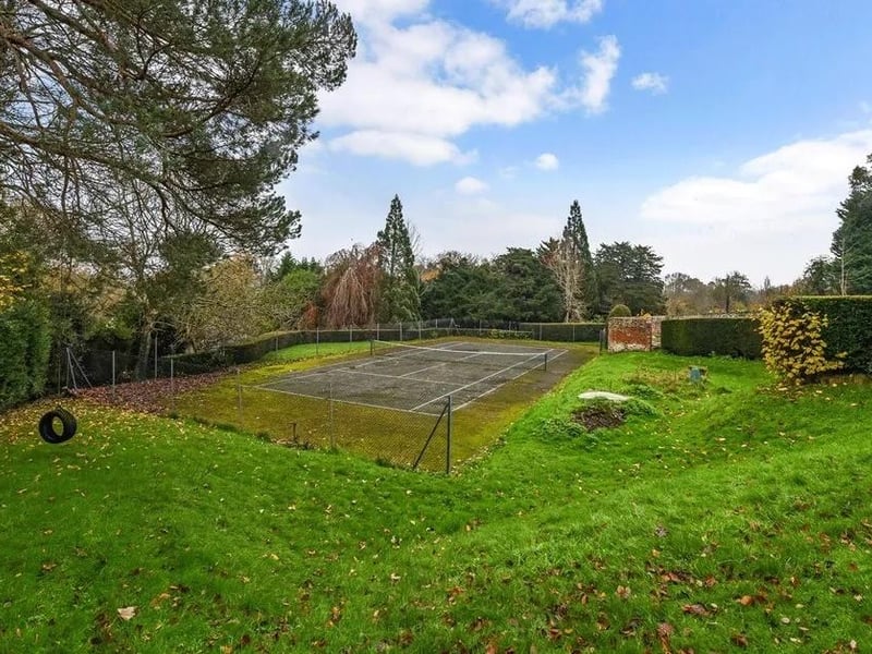 There is an orchard, walled swimming pool and tennis court