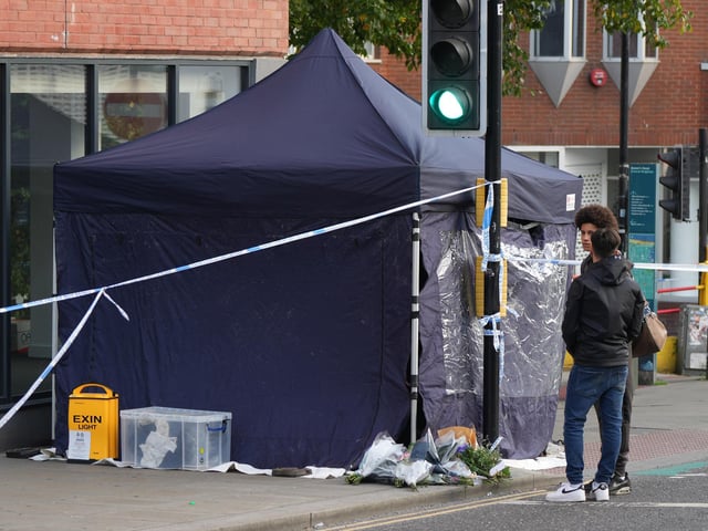 People gather at the scene to leave tributes
