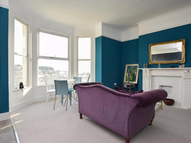 The spacious open plan living area has an original fire surround