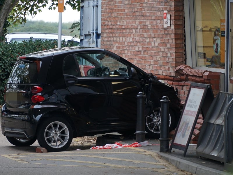 The photos show damage to one of the vehicles and the wall at the kiosk