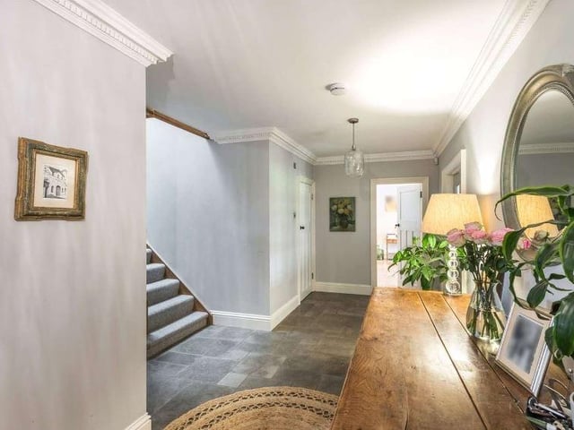There is a spacious entrance hall with adjacent boot room with limestone flooring