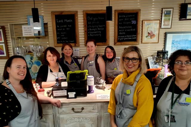 The volunteer team from Waitrose with Love It Again shop manager Tracy Patterson and Katheryn the assistant in the shop