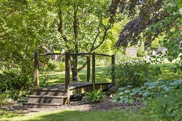 A bridge is one of many features in the garden.