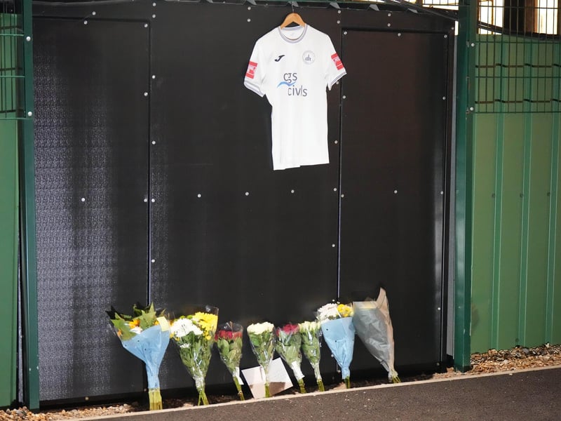 Chichester City FC and former Arsenal academy striker Billy Vigar has died after sustaining a "significant brain injury".
Vigar, 21 and born in Worthing, was injured during a game at Wingate and Finchley on Saturday in the Isthmian League Premier Division.
It is thought the injury was caused when he collided with a concrete wall, but the club has not confirmed this.
Vigar's family said on Thursday they were "devastated that this has happened while he was playing the sport he loved".
"After sustaining a significant brain injury last Saturday, Billy Vigar was put into an induced coma," the family said.
"On Tuesday, he needed an operation to aid any chances of recovery. Although this helped, the injury proved too much for him and he passed away on Thursday morning.
"The responses to the original update show how much Billy was loved and thought of within the sport." : Floral tributes to Billy Vigar are left at Chichester City FC