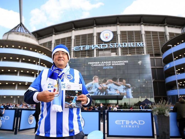 A Brighton and Hove Albion fan holds up a matchday programme ahead of the Premier League match between Manchester City and Brighton & Hove Albion at Etihad Stadium on September 29, 2018.