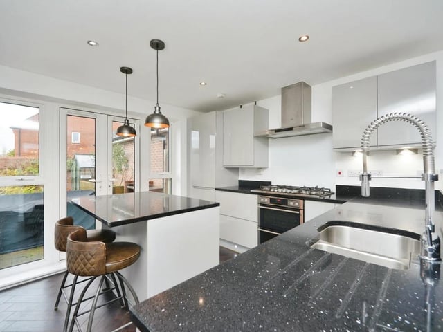 The modern kitchen diner has wall and floor mounted units, granite work surfaces and an island with inset cupboards