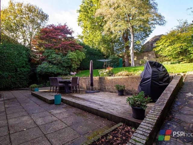 The rear garden is arranged over two levels with a paved terrace, a lawn and a second terrace area