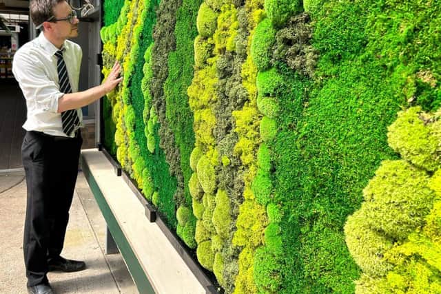 Paradise Park director, Darren Clift, at the 16-foot moss wall