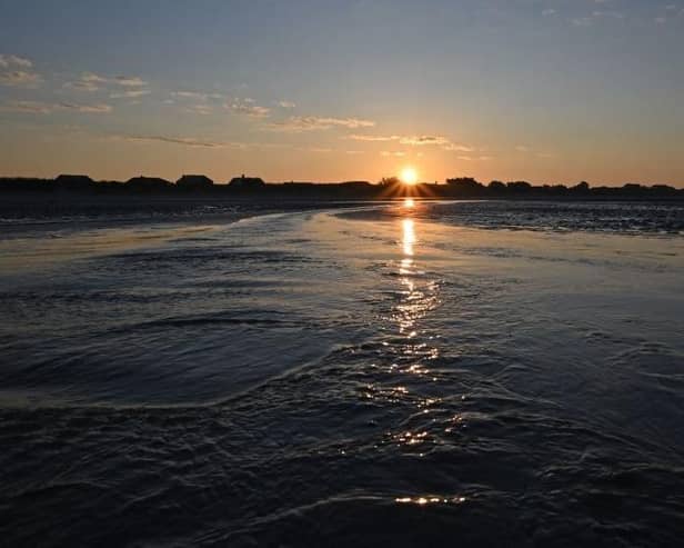 The sun rises over the beach at West Wittering on the south coast of England.