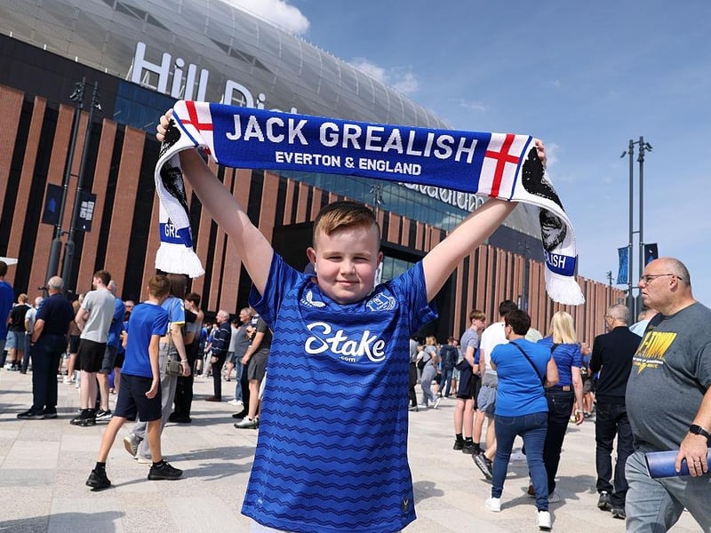 A young fan of Everton poses for a photo while holding a scarf which reads "Jack Grealish, Everton & England", as they enjoy the pre-match atmosphere prior to the Premier League match between Everton and Brighton & Hove Albion at Hill Dickinson Stadium