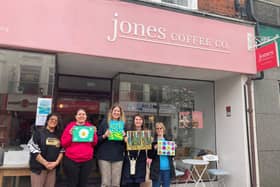 Kiran Harrison, lead performance practitioner at Superstar Arts, left, with the artists outside Jones Coffee Co.