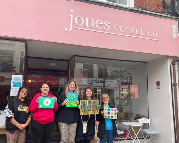 Kiran Harrison, lead performance practitioner at Superstar Arts, left, with the artists outside Jones Coffee Co.