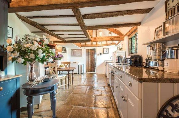 The kitchen has a partially vaulted ceiling, is galleried to the first floor and has stone paved flooring; it is fitted with a range of painted wooden units with granite worktops and it is served by a utility/boot room with space for further appliances, a secondary staircase rising to the first floor, and a pantry cupboard.