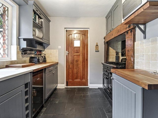 The kitchen has classic butcher block worktops and an inset range