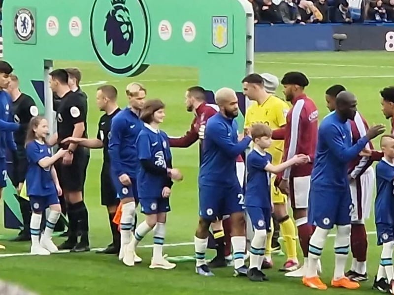 Alexis Fay meets the referee and the Aston Villa team