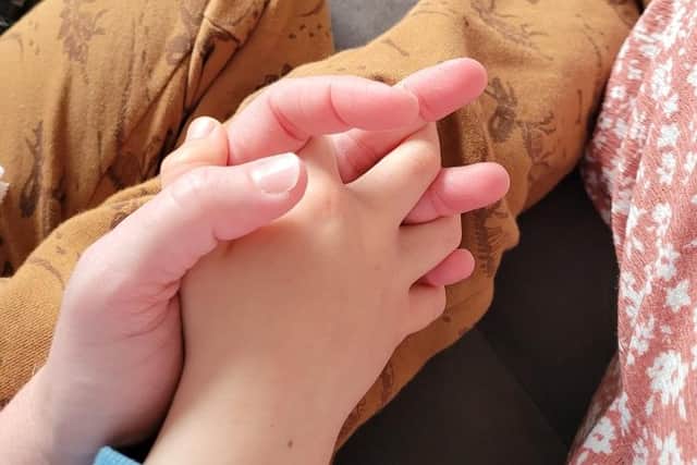 Catherine holding the hand of her foster child.