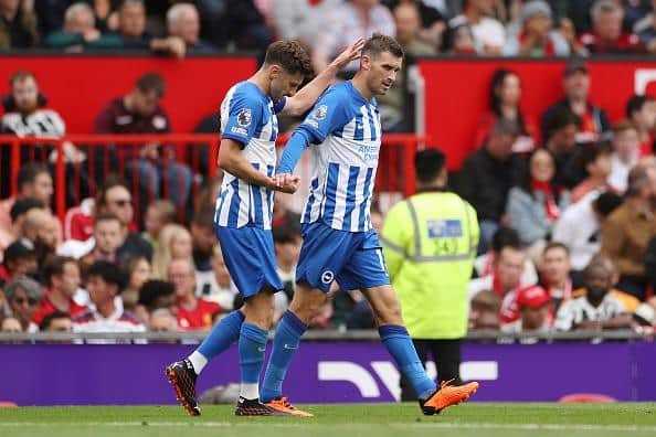 Pascal Gross of Brighton & Hove Albion celebrates with team mate Adam Lallana after scoring their sides second goal at Man United