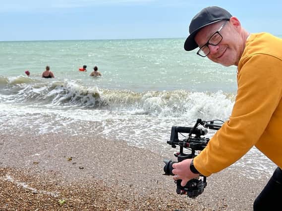 Kristian Coburn filming swimmers at Worthing beach