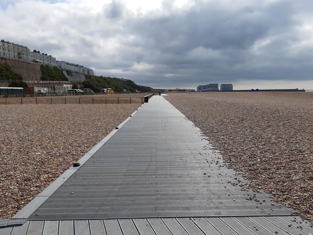 The England Coastal Path a boardwalk runs across the beach towards Brighton Marina