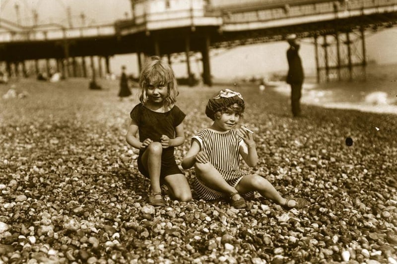 Two young girls on Brighton beach about to have a cigarette.