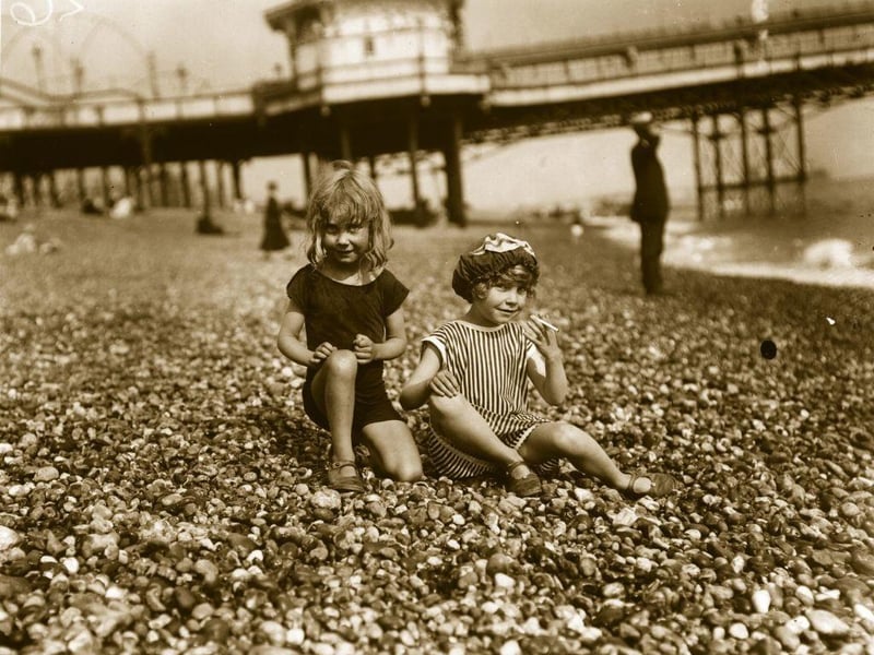 Two young girls on Brighton beach about to have a cigarette.