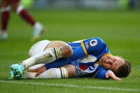 Solly March of Brighton lies injured on the floor during the Premier League match between Brighton & Hove Albion and Aston Villa