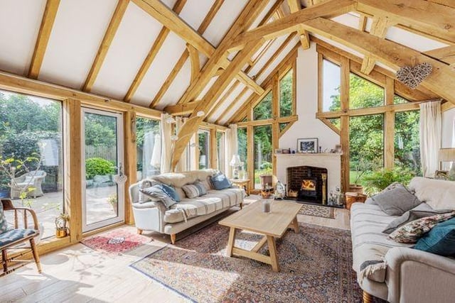 The oak beamed ceiling and windowed walls combine rustic inspiration with modern design sensibilities to give the living room a contemporary, but cosy, sense of character.