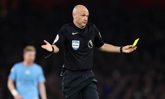 Referee Anthony Taylor awards a yellow card to Ederson for time wasting during the Premier League match between Arsenal FC and Manchester City at Emirates Stadium.