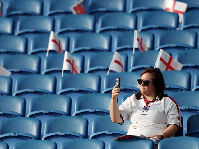 An England fan takes their seat inside the stadium.