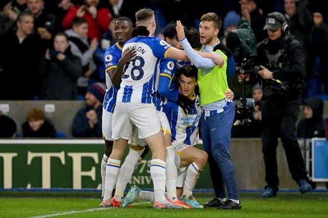 Brighton and Hove Albion midfielder Solly March is mobbed by his teammates after a two-goal display against Liverpool