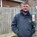 Cllr Glenn Haffenden with one of the offending poo bag dispensers