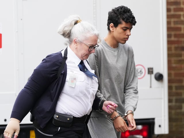A Sussex teenager accused of murdering his father and attempting to kill a woman and a boy has been pictured arriving at court in handcuffs.
