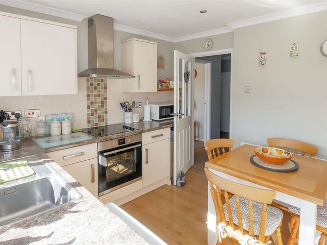 The modern fitted kitchen benefits from direct access to the patio