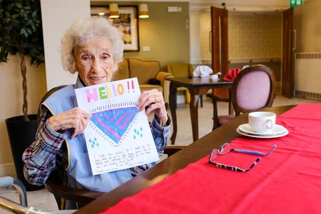 Margaret, one of the residents at Caer Gwent, with a cheery message she was sent by a pupil from Orchards Junior School