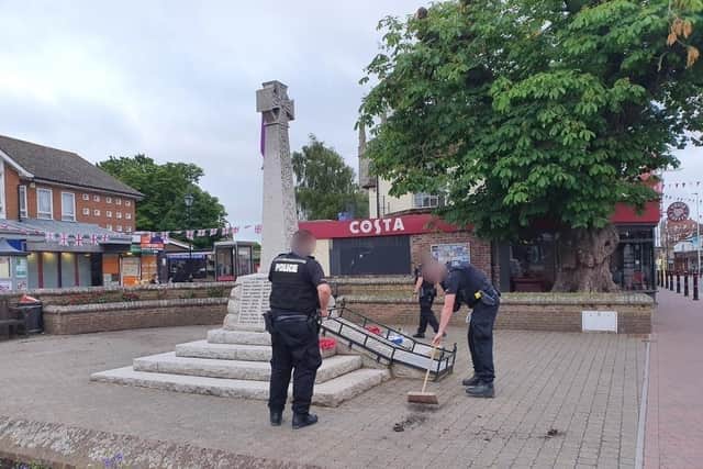 Officers clearing up the damage by the war memorial in Hailsham High Street. Picture from Sussex Police