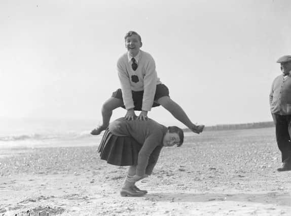 March 1929:  A couple of young women playing leap frog on the beach at Hove.