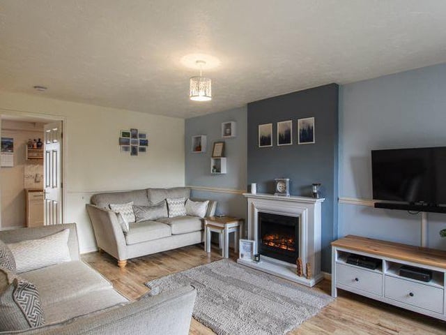 A second shot of the living room shows how easy it would be to relax in front of the TV or fire after a tough day at work.