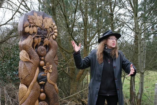 Sculptor Janine Creaye with the Binsted waymarker, which includes the Green Man and two Knucker Dragons