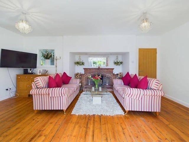 The living room has a large open fireplace and bay window seating