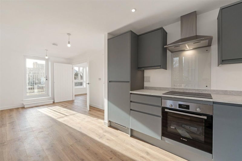 This apartment on the first floor is priced at £265,000. The open-plan layout effortlessly connects the dining area and kitchen, the bathroom has a bath and overhead shower, and there is a separate utility room.